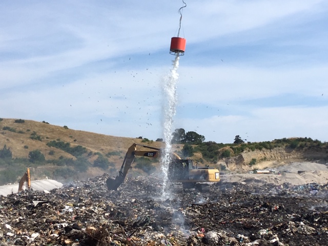 Helicopter with monsoon bucket dumping water on the fire.  