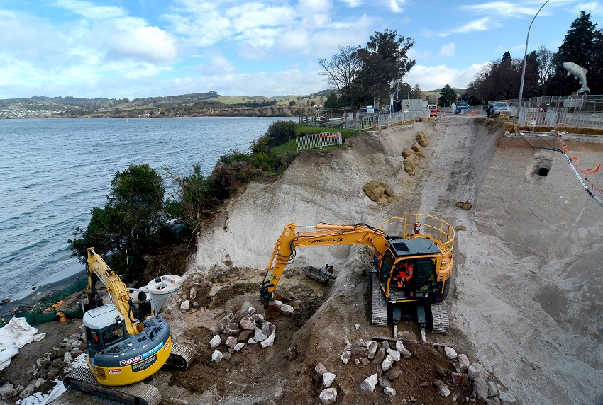Contractors preparing the washed-out cliff face for construction of a retaining wall.  