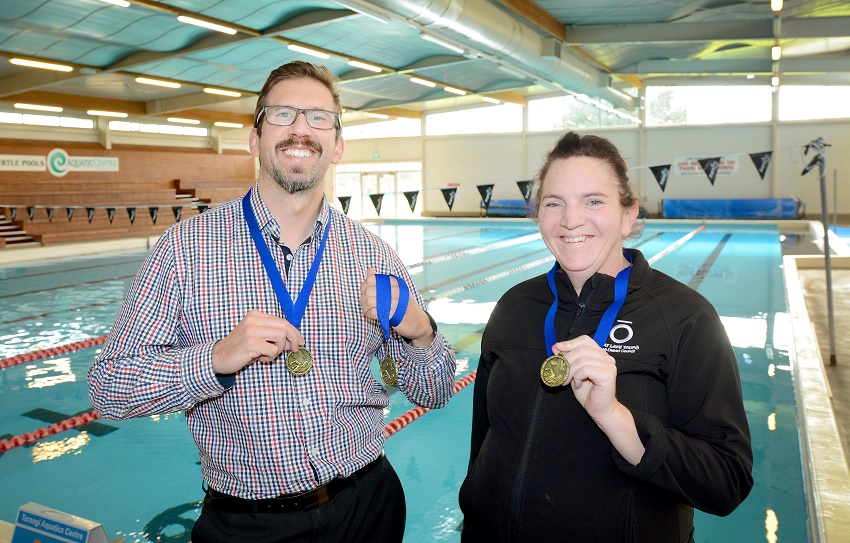 Scott Attenborough, left, and Suzanne Watson modelling Margaret Sweeney Challenge medals at the Turtle Pools.